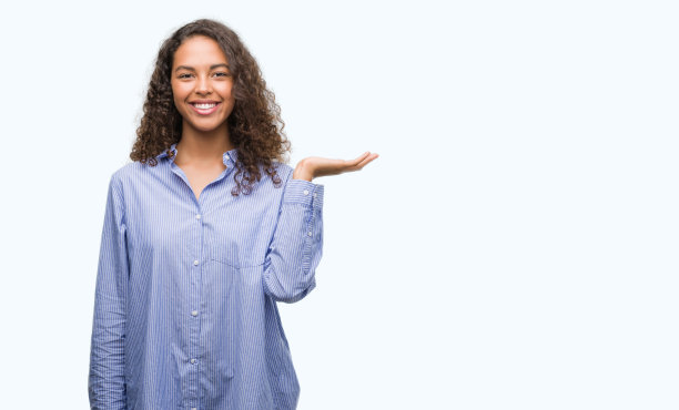 年轻的西班牙女商人面带微笑，用手掌指着镜头。图片下载