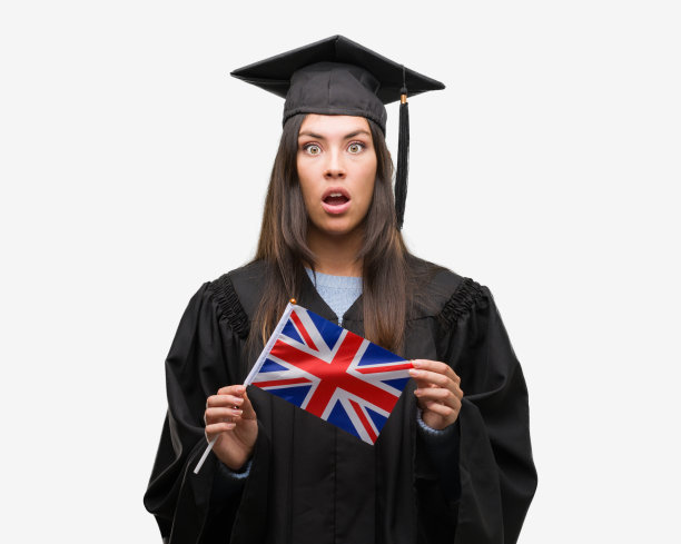 年轻的西班牙裔妇女穿着毕业制服举着英国国旗吓了一跳，脸上带着惊讶，害怕和兴奋的恐惧表情图片下载