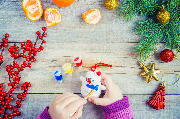 一个孩子画一个圣诞玩具，一个雪人。有选择性的重点。图片下载