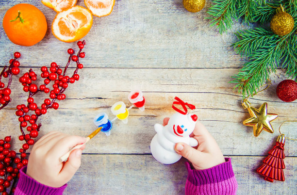 一个孩子画一个圣诞玩具，一个雪人。有选择性的重点。图片下载