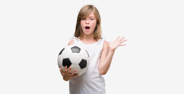 年轻的金发小孩抱着足球非常高兴和兴奋，胜利者的表情庆祝胜利尖叫与大微笑和举起手图片下载