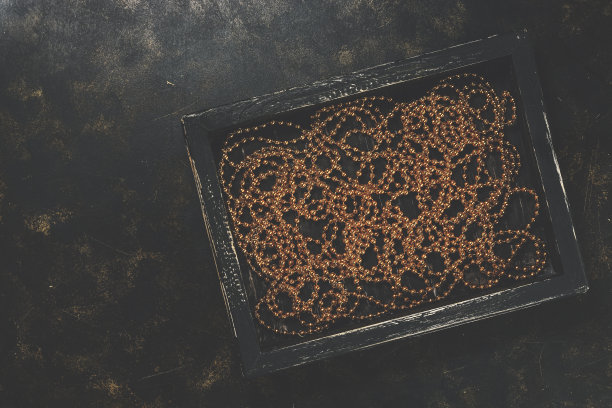 以乡村为背景的黑色木制托盘里的圣诞金珠。俯视图，复制空间。健美的照片。图片下载