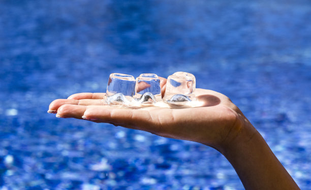 泳池中拿着冰块的手图片下载