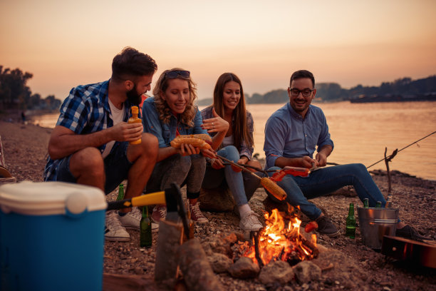 快乐的年轻朋友们在海滩上野餐图片下载