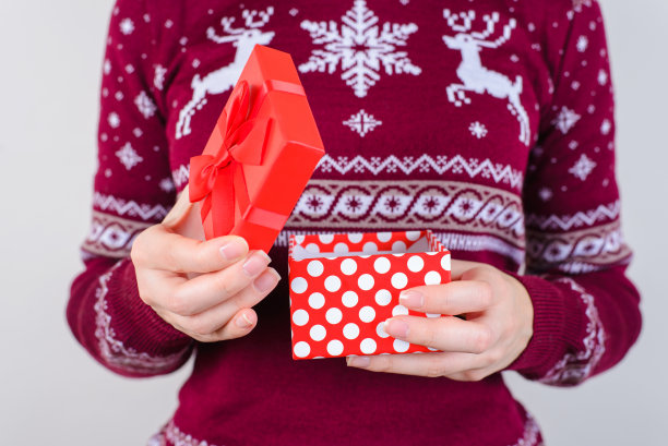 裁剪近距离的照片肖像手拿美丽的小与系蝴蝶结虚线盒子在手中看一边孤立在灰色的背景图片下载