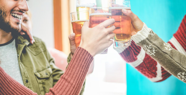 一群朋友在酒吧餐厅与啤酒欢呼-年轻人有乐趣喝酒和祝酒在时髦的酒吧的快乐时间-友谊和青年概念-专注于近距离的玻璃杯图片下载