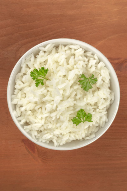 这是一碗煮熟的白色长米粒米饭配上欧芹的头顶照片，拍摄地点是一个带有复制空间的乡村木制背景图片下载