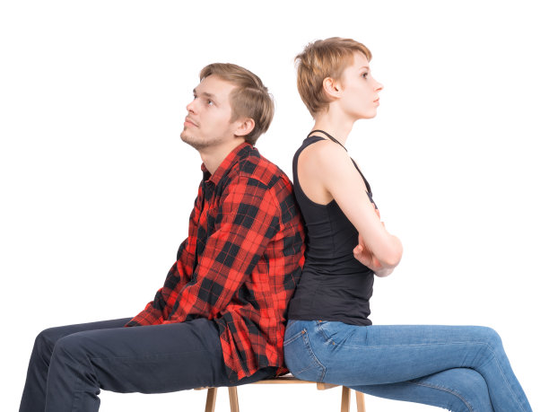 一对年轻夫妇坐在一张椅子上，孤立地看着不同的侧面图片下载