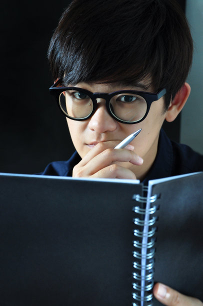 亚洲妇女拿着钢笔和黑名册图片下载