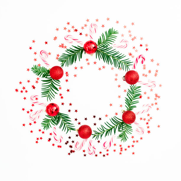 由冷杉树枝和红球装饰的圣诞框架与五彩纸屑在白色的背景。节日的背景。平躺，俯视图图片下载