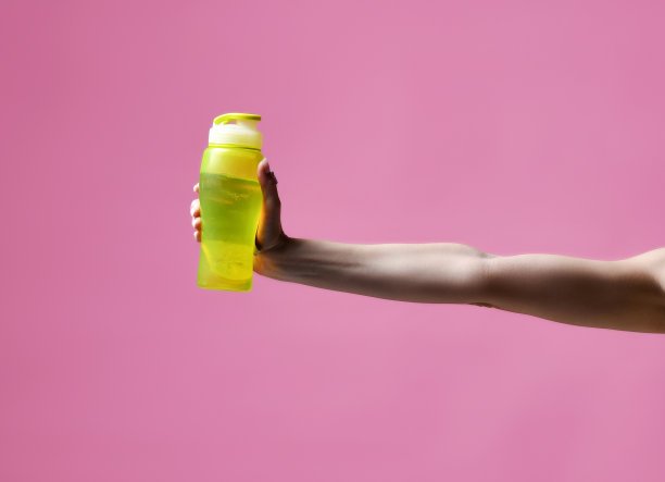 女人手里拿着粉色的运动塑料瓶水图片下载