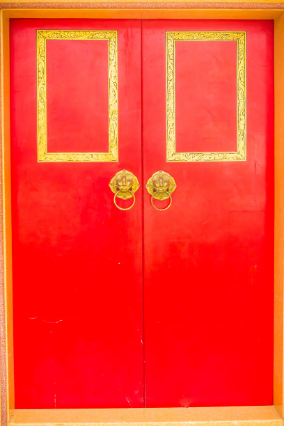 金色的狮子门环，红色的木门上挂着戒指。紧闭木质中式红色门与狮子头门把手。图片下载