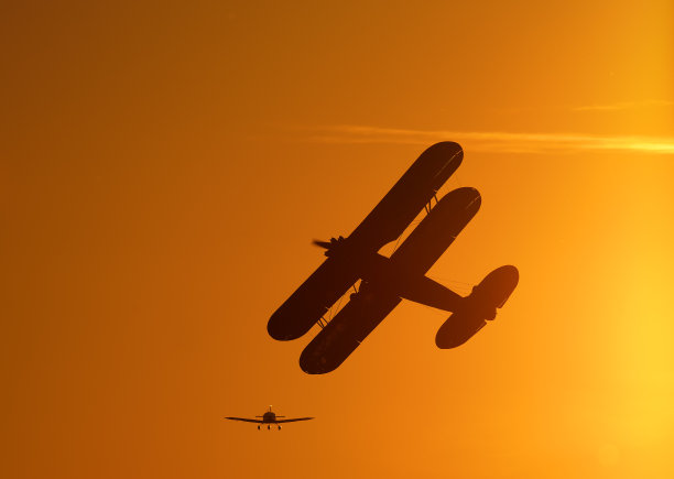 复古单引擎螺旋桨双翼飞机的轮廓飞行图片下载