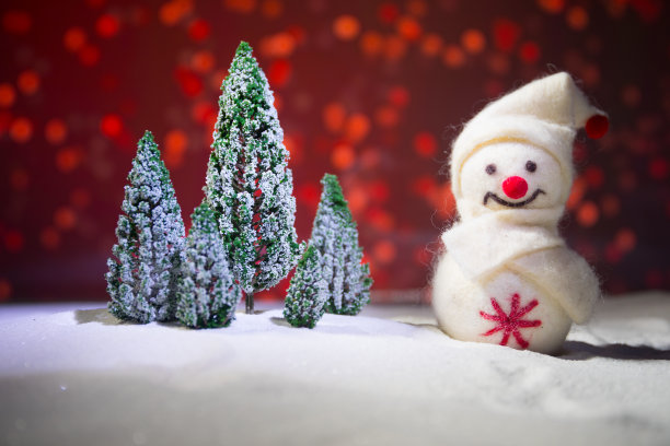 节日的背景。雪人装扮成圣诞老人与圣诞球在灯光背景照片有一个空的空间为您的文字图片下载