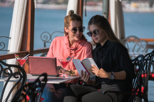 女性朋友在户外咖啡馆用笔记本电脑工作图片下载