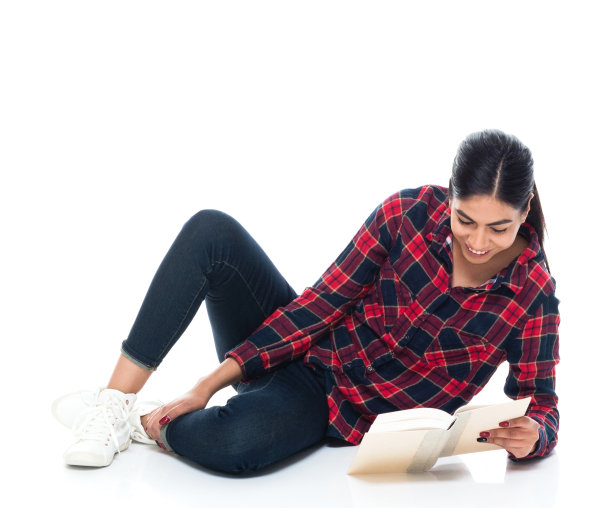 美丽年轻的拉丁美洲女性躺在地板上看书图片下载