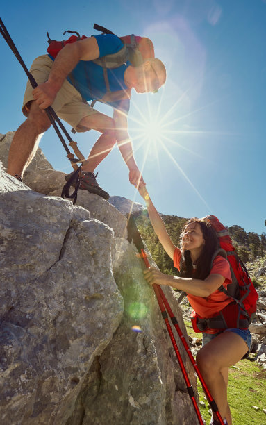 一个女孩的帮助之手在登山。图片下载