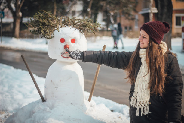 快乐女孩触碰雪人鼻子素材图片