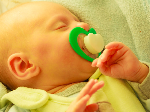 小新生儿叼着奶头睡觉的特写图片下载