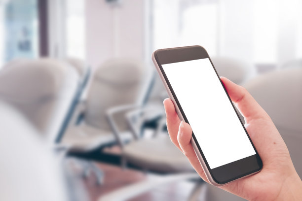 在机场用智能手机的女人的手。图片下载