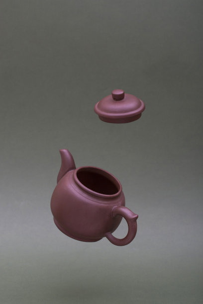 空中挂着一只带帽的棕色茶壶图片下载