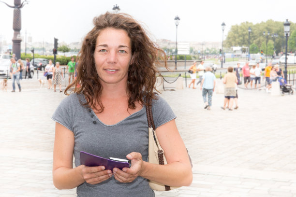 法国波尔多市的漂亮女游客，带着智能手机应用旅行指南图片下载