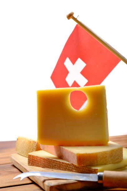 伯尔尼州产的用牛奶制成的圆孔中等硬度的奶酪，上面有瑞士国旗图片下载