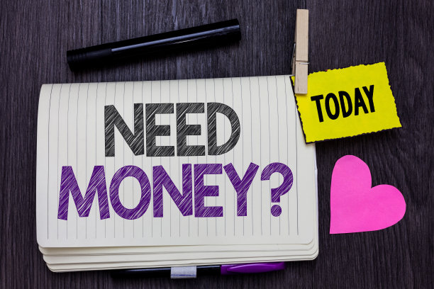 文本符号显示需要钱的问题。概念照片询问某人是否需要现金或贷款打开笔记本，晾衣夹夹着提醒标记心木制背景。图片下载