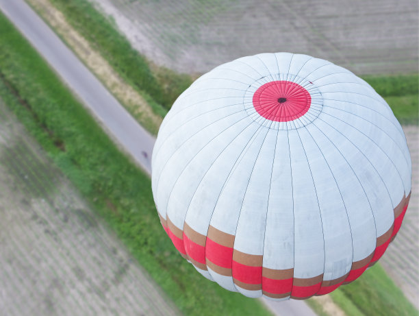 白色的热气球带有红色和金色的条纹盘旋在下萨克森州的费尔德马克上空，从上面看气球图片下载