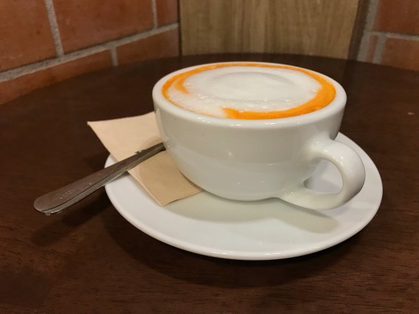 木桌上放着一杯奶泡的热茶图片下载