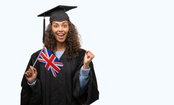 年轻的西班牙裔妇女穿着毕业制服举着英国国旗尖叫自豪和庆祝胜利和成功非常兴奋，欢呼的情绪图片下载