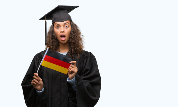 年轻的西班牙裔女子穿着毕业制服举着德国国旗吓得目瞪口呆，脸上带着害怕和兴奋的恐惧表情图片下载