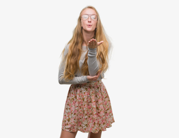 金发少女穿着花裙子看着镜头飞吻与手在空中是可爱和性感的。爱的表达。图片下载