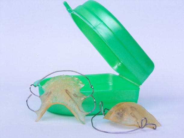 两个可移动的正畸器具及盒子。可移动的牙齿矫正器。白色背景。图片下载