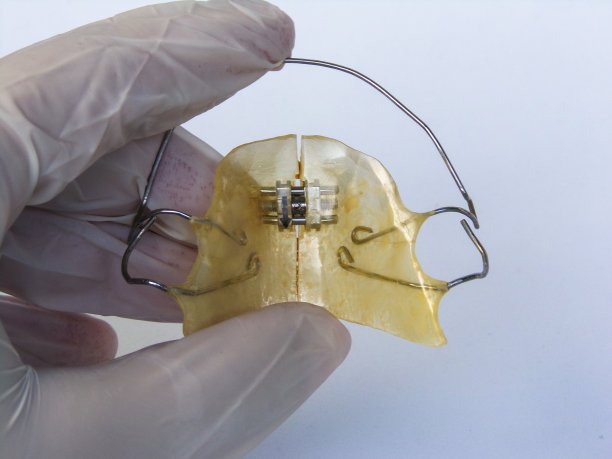 牙科医生展示可移动的正畸器具。可移动的牙齿矫正器。白色背景。图片下载
