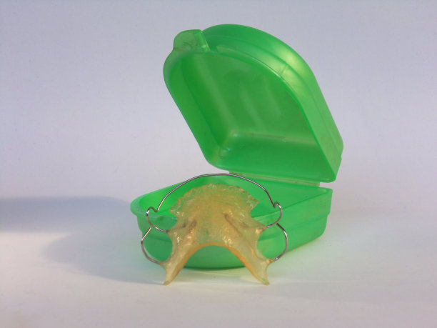 可移动正畸用具及盒。可移动的牙齿矫正器。白色背景。图片下载