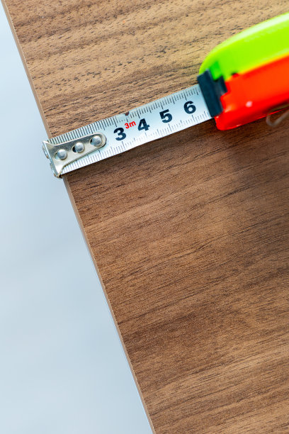 用绿色和橙色的轮盘赌丈量一张木桌图片下载