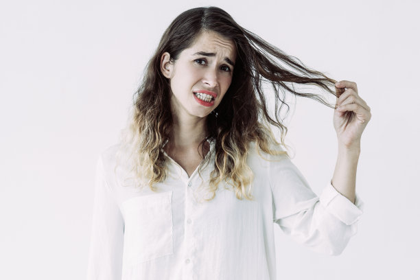 一个不幸的年轻女人，手里拿着一缕头发图片下载