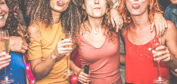 年轻的女人跳舞和喝香槟在周末的派对之夜-快乐的朋友有乐趣在一起吹口香糖-娱乐，友谊和青春的概念-集中在中心女孩的嘴图片下载