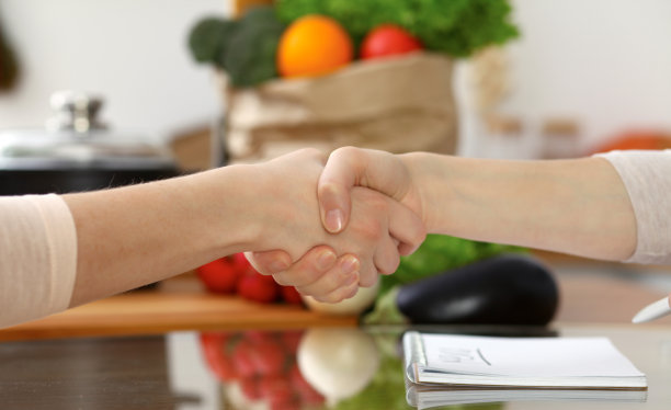 人类握手的特写。两个女人在厨房里互相握手。烹饪，友谊或家庭有趣的概念图片下载