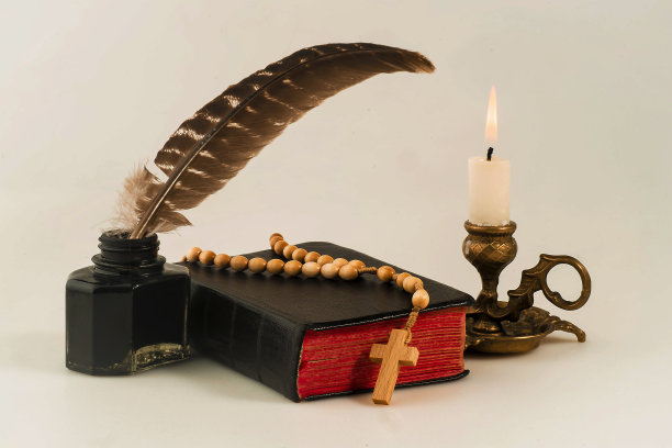 一本带念珠的书，一支带着笔的枪乌贼，还有一支点燃的蜡烛图片下载