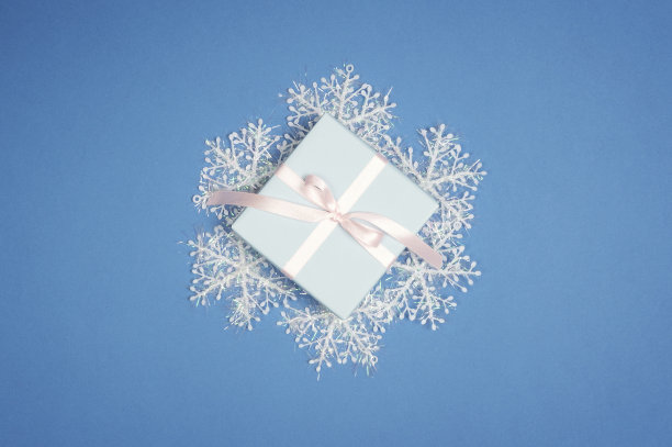 装饰用的白色雪花和蓝色背景的新年礼盒。圣诞节平躺图片下载