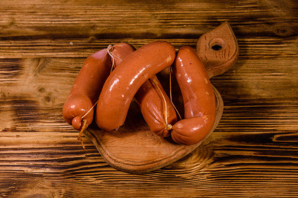 一堆香肠放在木砧板上图片下载