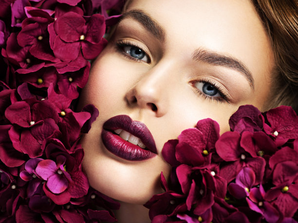 美丽的年轻女子与鲜花。图片下载