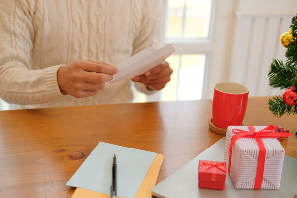 男人打开寄信的圣诞贺卡，送上节日祝福与圣诞装饰图片下载