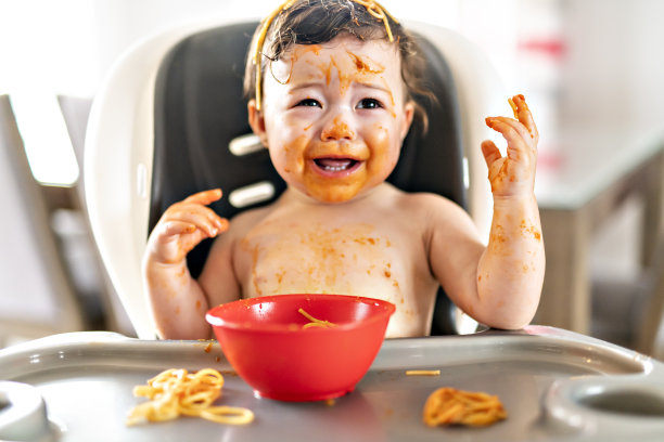 小女孩，午餐吃意大利面把家里的厨房弄得一团糟图片下载