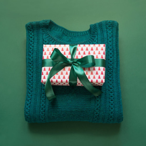圣诞礼物用丝带，毛衣用绿色表面。顶视图。节日卡片。圣诞节的概念。图片下载