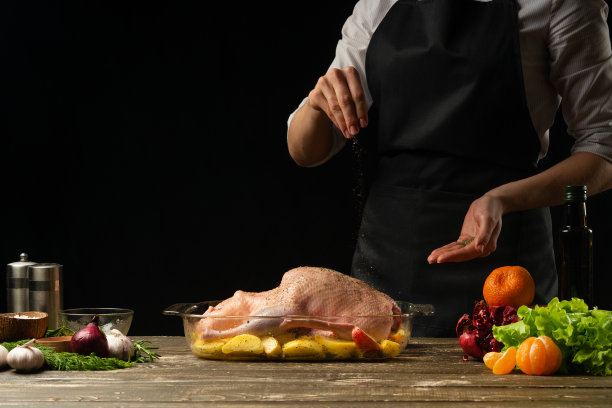 厨师用水果烹饪北京烤鸭，以黑色为背景。横向照片，菜单和设计空间，餐厅，酒店业务。图片下载