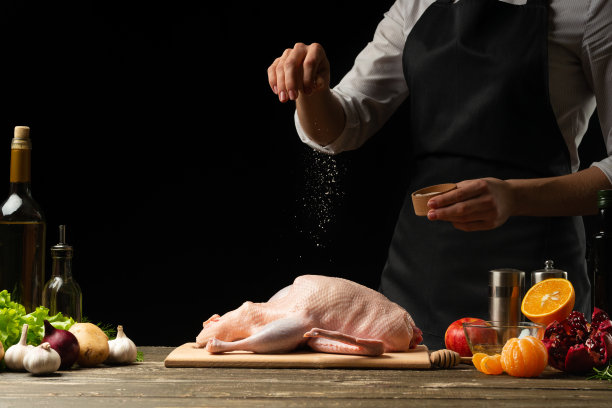 厨师用水果烹饪北京烤鸭，以黑色为背景。横向照片，菜单和设计空间，餐厅，酒店业务。图片下载