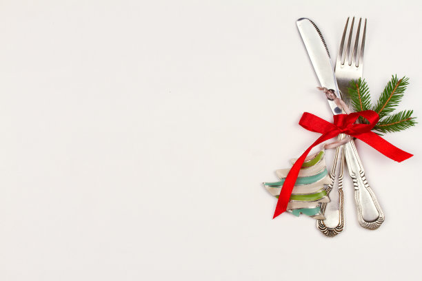 用餐具、松枝、丝带和装饰品装饰在白色的桌子上。寒假和节日背景图片下载